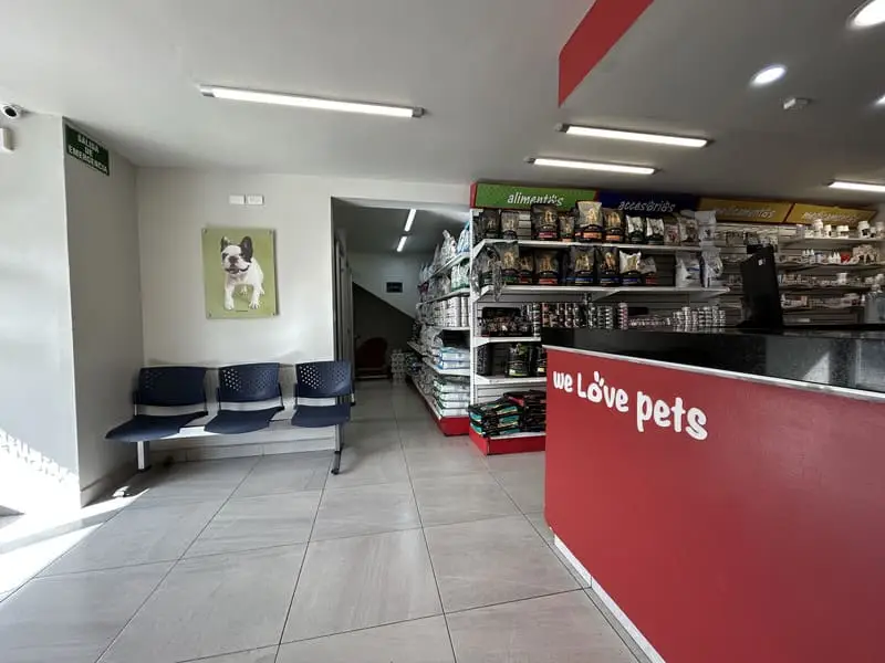 Recepción y sala de espera del Hospital Veterinario Lomont® Vasconcelos, con mostrador de atención y área de alimentos y accesorios para mascotas